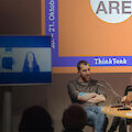 There are 5 people sitting on a stage at a table with microphones. Behind them is a screen that reads: Think Tank: We do/are Photography.