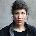 Portrait of Pauline M'Barek. Her dark hair is pinned up and she is wearing a woolen jacket.