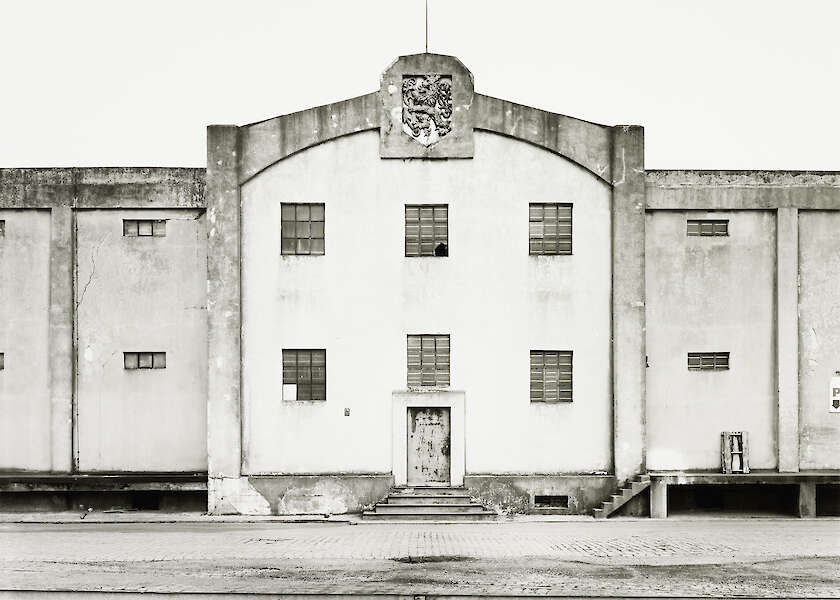 Tata Ronkholz: Lagerhalle mit Löwenwappen, 1979  Aus der Serie „Rheinhafen Düsseldorf“, 1979–1981 © VAN HAM Art Estate: Tata Ronkholz, 2025